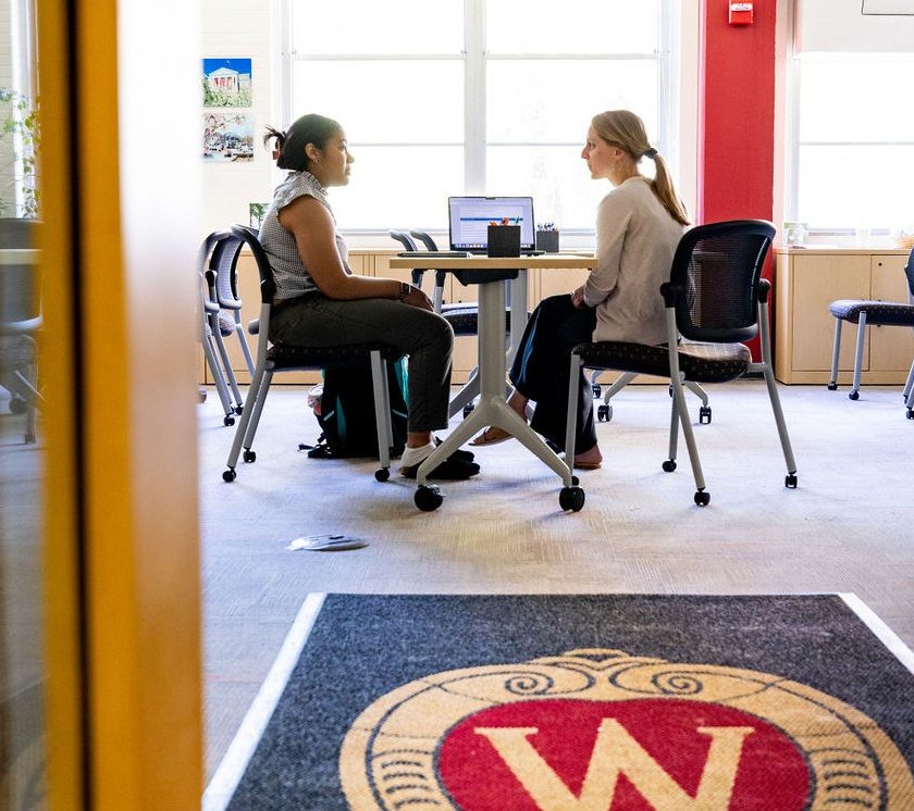 A career advisor and student sit together at a table.
